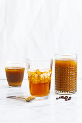 Iced coffee with cream and vanilla in various glasses on white background. Summer cocktail or dessert