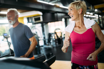 Fit senior sporty couple working out together at gym