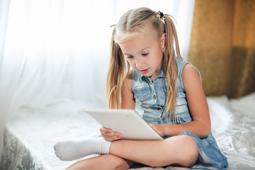 little girl playing tablet.