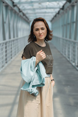 Beautiful woman posing on camera with denim jacket in her hands.