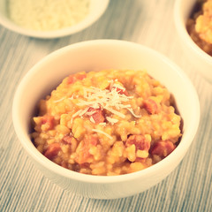 Fresh homemade carrot risotto made with pureed carrot and roasted carrot pieces, photographed with natural light (Selective Focus, Focus in the middle of the risotto) (Digitally Altered: Toned Image)