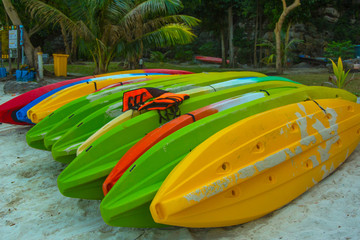 A few upside down kayaks laying among of palm trees