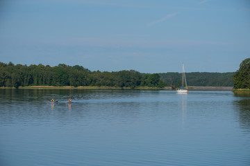 summer day at Vaxholm with sailboat and canoers on a tranquil water