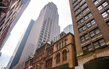 New York, Manhattan. High buildings view from below against blue sky background
