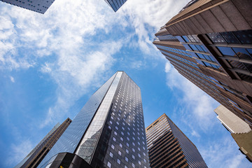 Fototapeta na wymiar New York, Manhattan. High buildings view from below against blue sky background