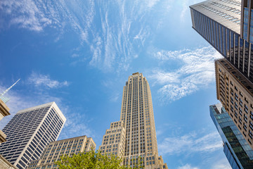 New York, Manhattan. High buildings view from below against blue sky background