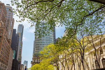 New York, Manhattan. High buildings view from below against blue sky background, sunny day in spring