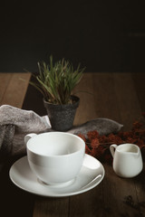 Empty cup of coffee decoration with coffee bean low light mood and tone on wooden table background