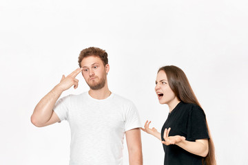 Studio shot of a couple quarreling. Angry woman shouting at the partner