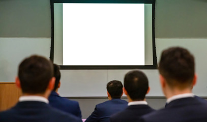 Seminar audience in class room. Blank white board, rear view