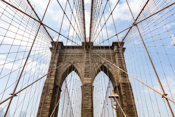 Brooklyn Bridge detail against blue cloudy sky background. New York city, Manhattan