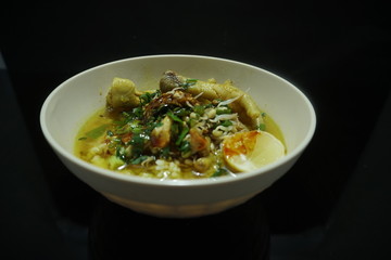 chicken porridge on a white bowl isolated on black background