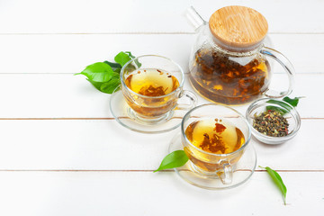 teapot and cups of tea on a white wooden background