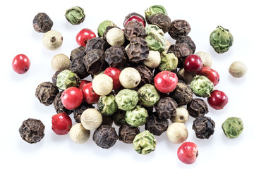 Black, white, green and red peppercorns isolated on white background.