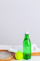 Sports bottle with towel on light background