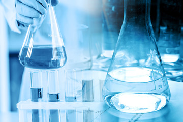 hand of scientist holding flask with lab glassware in chemical laboratory background, science laboratory research and development concept
