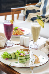 Healthy organic vegetarian dishes and glasses of detox drinks served on the restaurant table.	