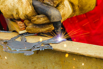 Man making art using metal cutter.