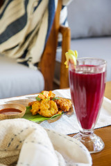 Vegetable fritters with tomato sauce served with a glass of freshly squeezed juice, healthy snack 