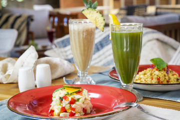 Healthy organic vegetarian dishes and glasses of detox drinks served on the restaurant table.	