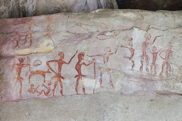 Prehistoric painting by primitive local caveman on the stone wall showing the hunting and...