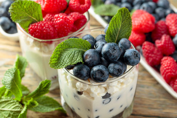 Cottage cheese with cream, raspberry and blueberry garnished with fresh mint.