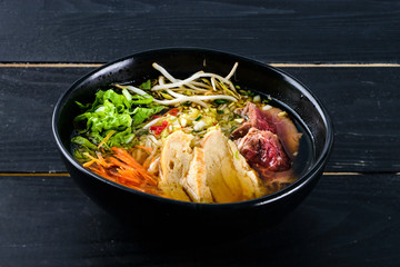 Spicy Asian beef soup with noodles and chinese vegetables