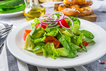 The salad with an avocado and tomatoes on a striped napkin