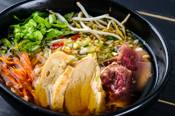 Spicy Asian beef soup with noodles and chinese vegetables