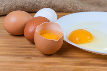 Broken eggs in open shell and on dish close-up