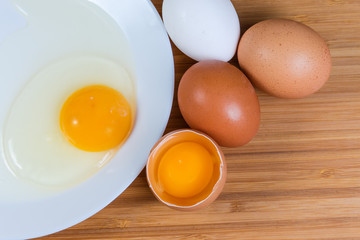 Broken eggs in open shell and on dish, top view