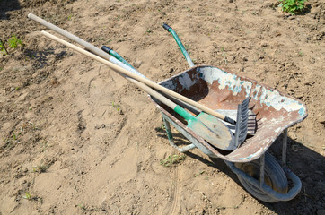 Wheelbarrow with a shovel, rake and shovel for household and construction work