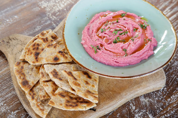 Beetroot hummus with pieces of freshly baked naan bread