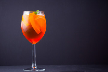 Cocktail aperol spritz on black background. Summer alcohol cocktail with orange fruit and fresh...