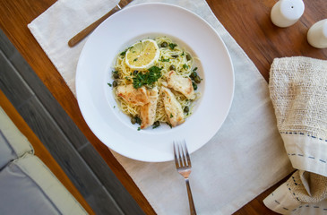Battered salmon fish fillet dinner with noodles on a plate	