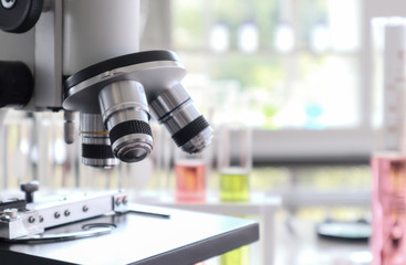 Fototapeta na wymiar Close up of microscope in laboratory with blurred background of glass test tube stack.