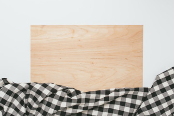 Cutting board partially covered by kitchen cloth over white background