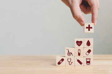 Hand arranging wood block stacking with icon healthcare medical, Insurance for your health concept