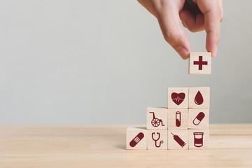 Hand arranging wood block stacking with icon healthcare medical, Insurance for your health concept