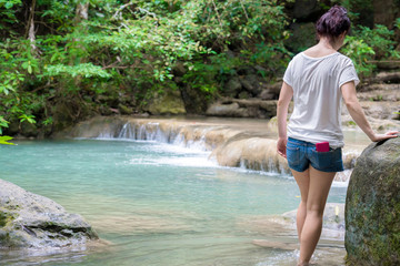 Young girl traveling at beautiful Erawan waterfall National Park Kanchanaburi, Thaialnd