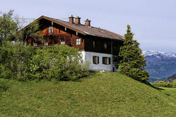 Classic apline house on the grass hill top with wooden facade