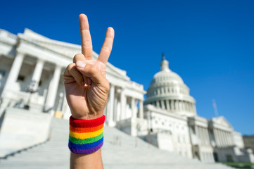 Hand with gay pride rainbow wristband making a peace sign in front of the Capitol Building in Washington, DC, USA