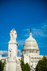 Obraz premium Scenic western view of the United States Capitol Building dominated by the Peace Monument with lush summer foliage in Washington DC, USA