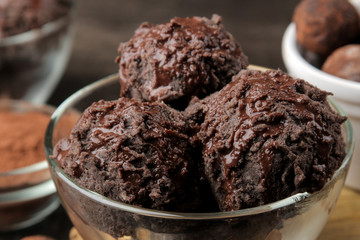 Chocolate ice cream with liquid chocolate with almonds and coffee beans on a dark background.