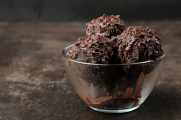 Chocolate ice cream with liquid chocolate with almonds and coffee beans on a dark background.