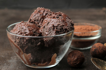 Chocolate ice cream with liquid chocolate with almonds and coffee beans on a dark background.