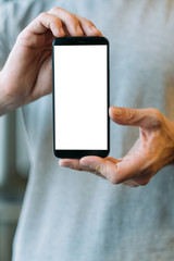Mobile web application. Closeup of white mockup smartphone screen in man hands. Copy space.