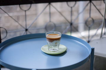 A beautiful glass of iced with fresh milk topped with espresso shot layer on station coffee. selective focus 