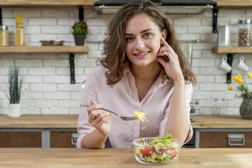 Obraz na płótnie Canvas Brunette woman eating a salad