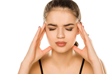 Naklejka premium Young beautiful woman with headache posing on white background